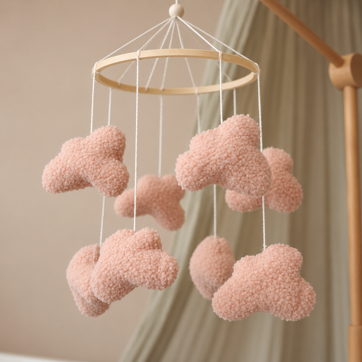 Gros plan sur la texture bouclée rose poudré du mobile bébé Nuages bouclés roses