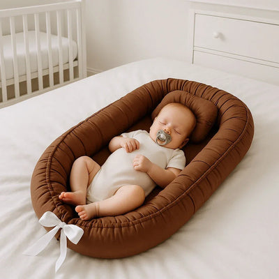 bébé dormant dans un réducteur de lit marron sur un lit, chambre bébé moderne