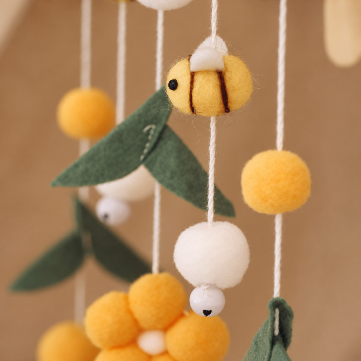 Mobile bébé Abeilles jaunes suspendu au-dessus d’un lit bébé avec support en bois