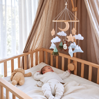 Gros plan sur l’ours brun en feutre du mobile bébé artisanal