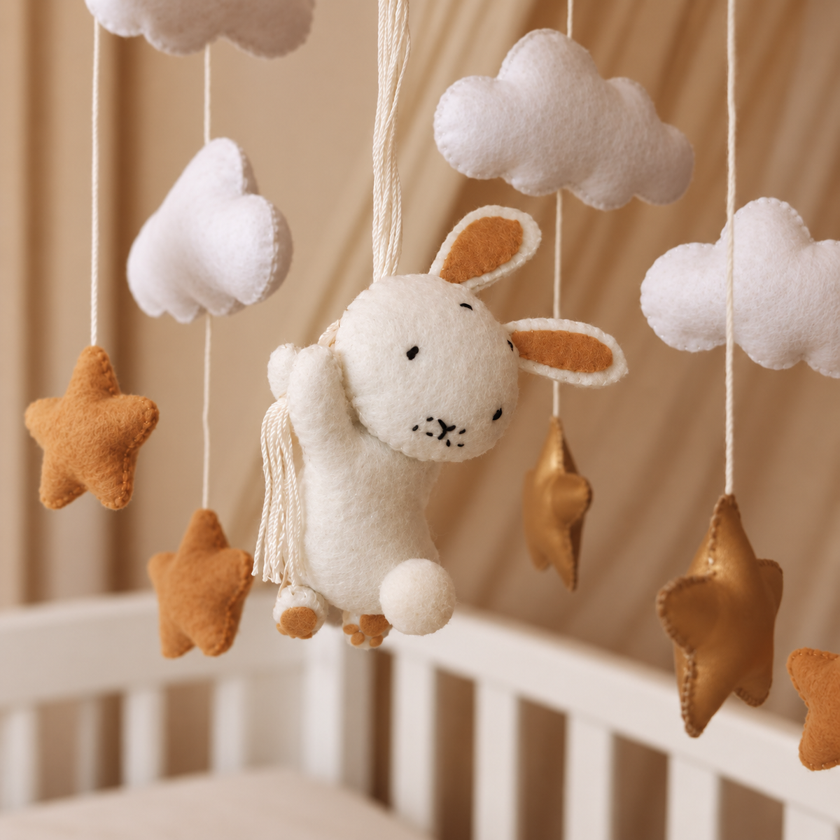 Mobile bébé Lapin avec nuages, étoiles caramel et élément doré suspendu au-dessus du berceau
