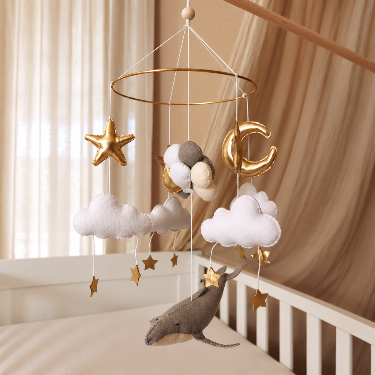 Mobile bébé Baleine & Ballons suspendu au-dessus d’un lit bébé dans une chambre aux tons naturels