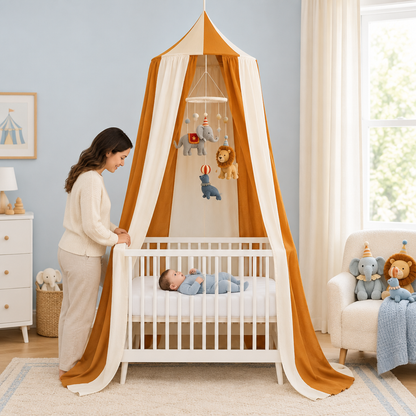 Bébé avec ciel de lit Caramel Circus et mobile cirque dans une chambre bleu doux