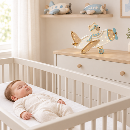 Bébé endormi avec la veilleuse Avion sur une commode