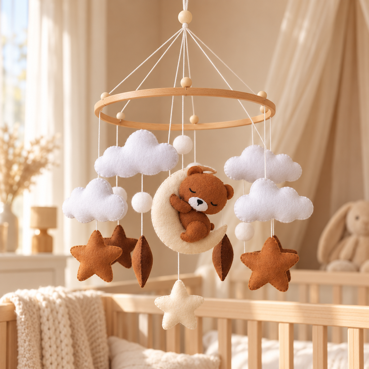 Gros plan sur l'ourson endormi posé sur la lune du mobile bébé