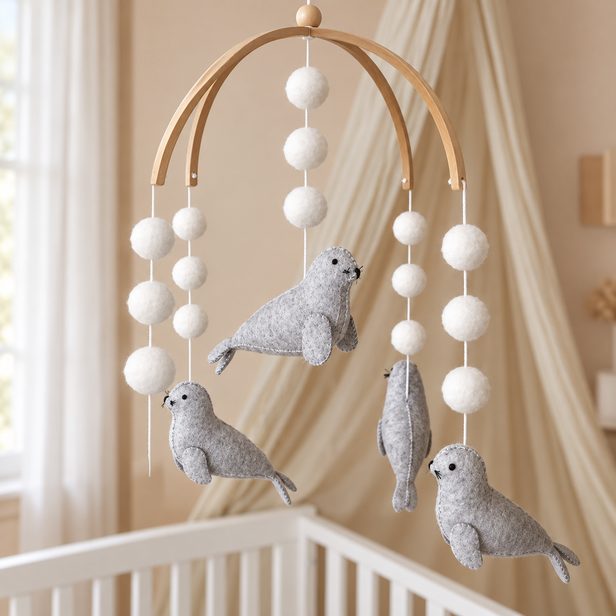Vue carrée du mobile bébé Phoques avec structure en bois et pompons blancs