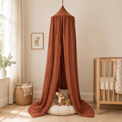 Ciel de lit bébé à rayures marron avec peluches biches dans une chambre beige