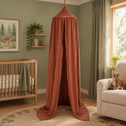 Ciel de lit bébé à rayures marron avec peluches biches dans une chambre vert sauge
