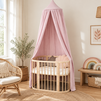 Ciel de lit bébé rose tendre dans une chambre bohème crème