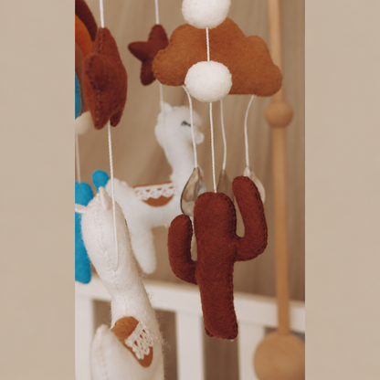 Gros plan sur les éléments en feutre du mobile bébé artisanal Lama