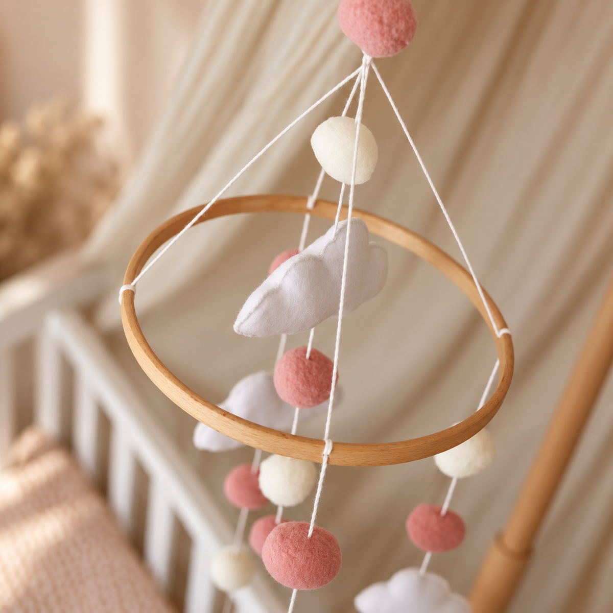 Gros plan sur un cœur rose en feutre du mobile bébé artisanal Petits Cœurs