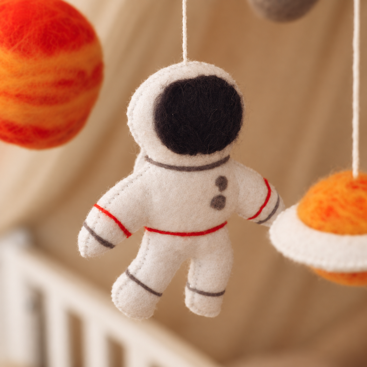 Détail du mobile bébé Astronaute avec planète orange en feutre