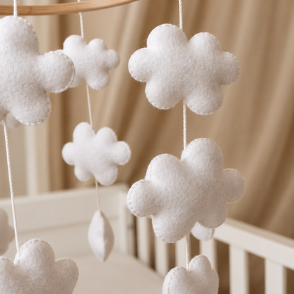 Gros plan sur les nuages en feutrine du mobile bébé artisanal