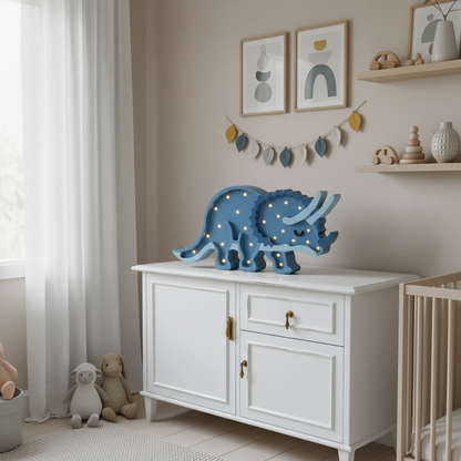Veilleuse bébé Tricératops bleu pastel dans une chambre enfant cosy