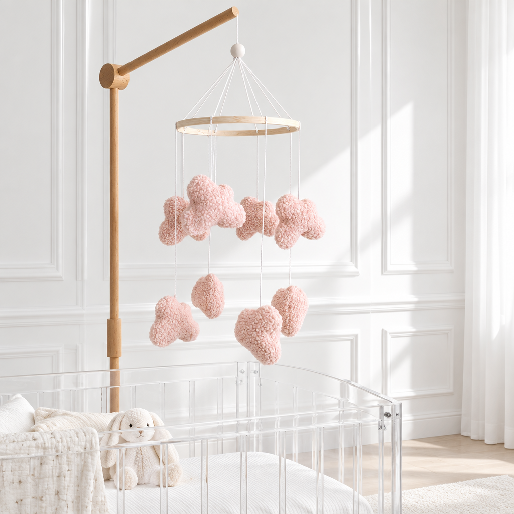 Mobile Nuages bouclés roses avec support en bois dans une chambre contemporaine blanche