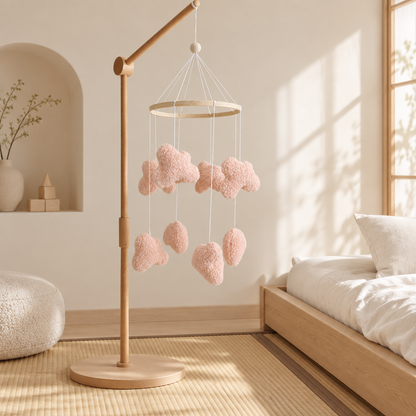 Mobile bébé Nuages bouclés roses avec support en bois dans une chambre japandi