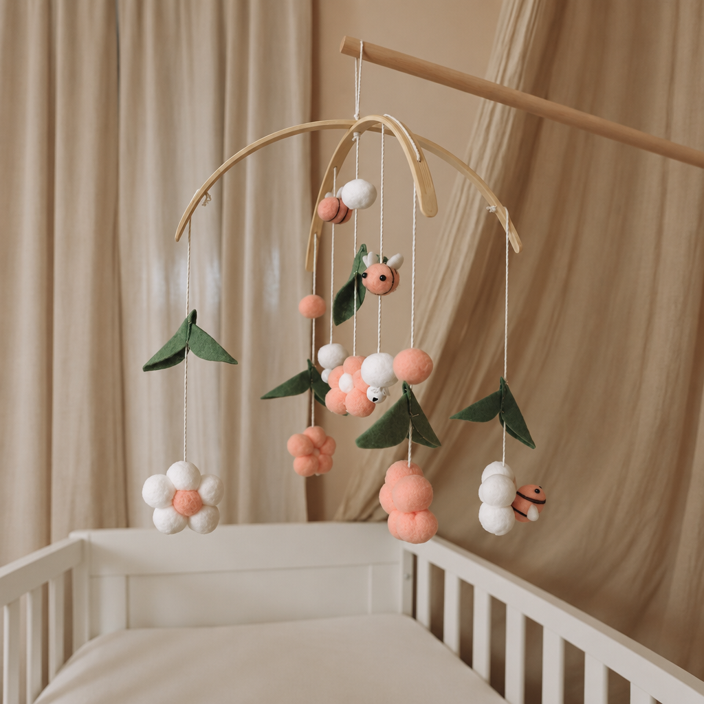 Mobile bébé Abeilles roses suspendu au-dessus d’un lit bébé